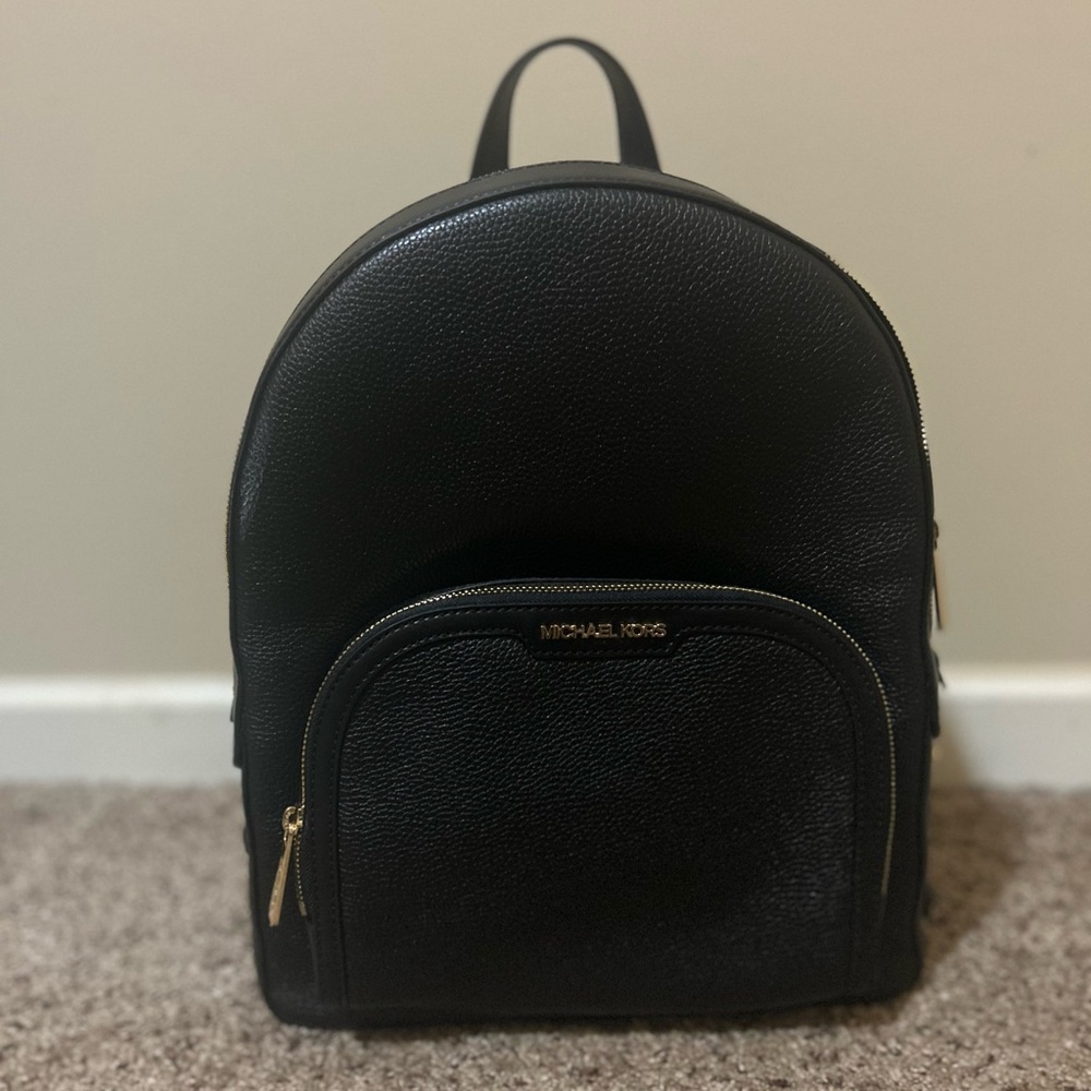 Michael Kors black backpack purse with gold hardware.